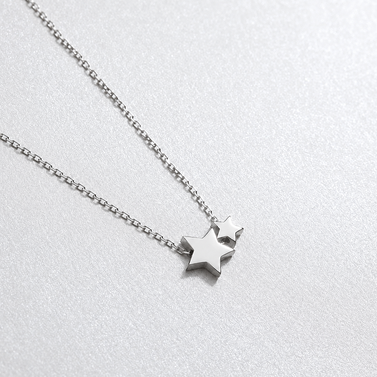 Silver star necklace on a light gray background